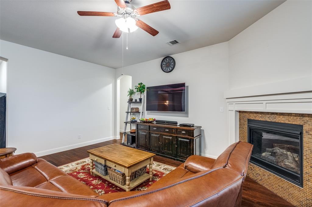 4217 Switchgrass Street Celina, TX 75009 - Photo 5 of 25 a living room with furniture a flat screen tv and a fireplace