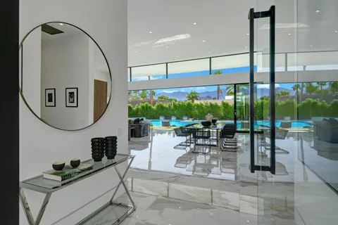 a living room with furniture a floor to ceiling window and floor to ceiling window