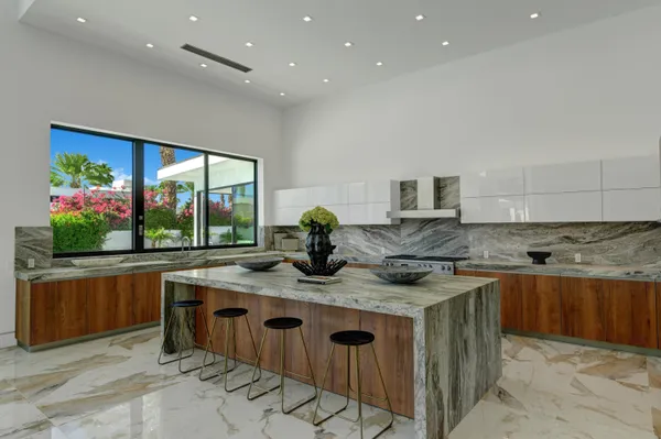 a kitchen with kitchen island granite countertop a sink and a stove