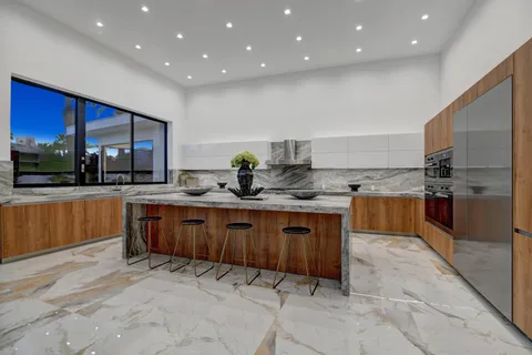 a kitchen with stainless steel appliances granite countertop a sink counter space cabinets and a large window