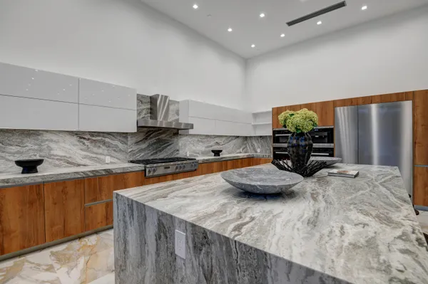 a kitchen with granite countertop a sink a stove and a wooden cabinets