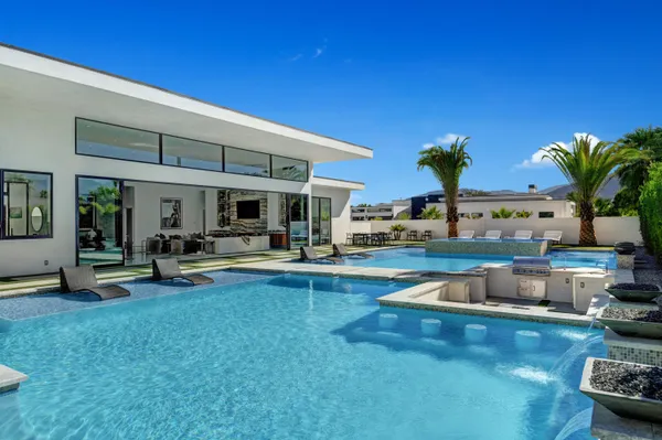 a view of a swimming pool with outdoor seating and plants