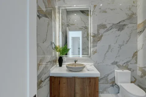 a bathroom with a granite countertop sink a toilet and shower