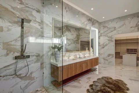 a bathroom with a tub a mirror and a shower