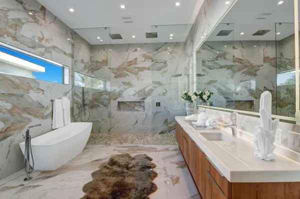 a bathroom with a tub sink and mirror
