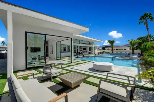 a view of a house with swimming pool and sitting area