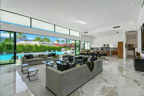 a living room with furniture a rug and a floor to ceiling window