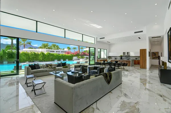 a living room with furniture a rug and a floor to ceiling window