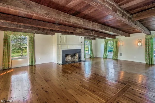 a view of empty room with wooden floor and fireplace