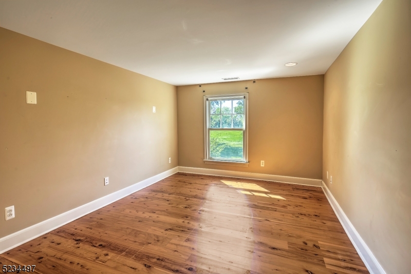 1815 Burnt Mills Road Bedminster, NJ 07921 - Photo 22 of 27 an empty room with wooden floor and windows