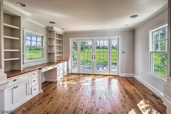 a view of a kitchen with wooden floor and windows