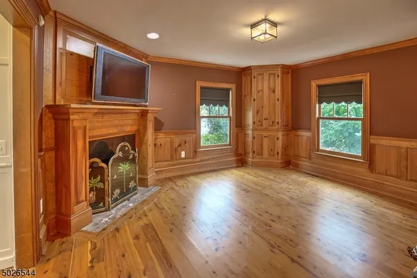 a view of a livingroom with a fireplace wooden floor and a window