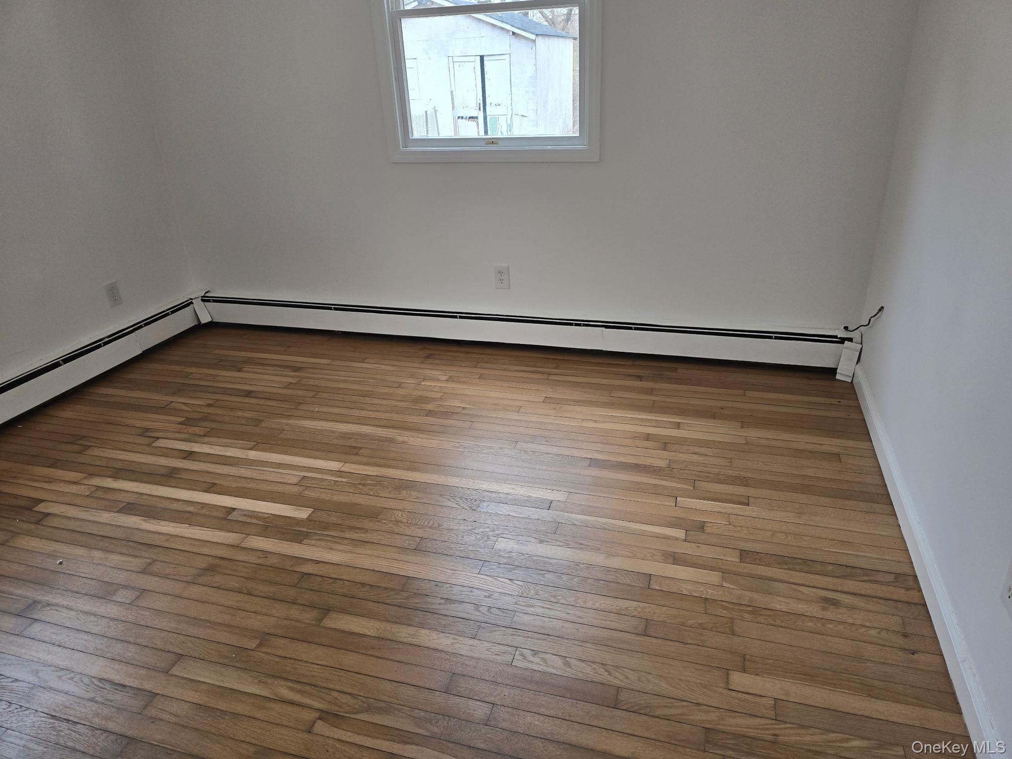 310 A Frowein Road Center Moriches, NY 11934 - Photo 4 of 5 a view of an empty room with wooden floor and a window