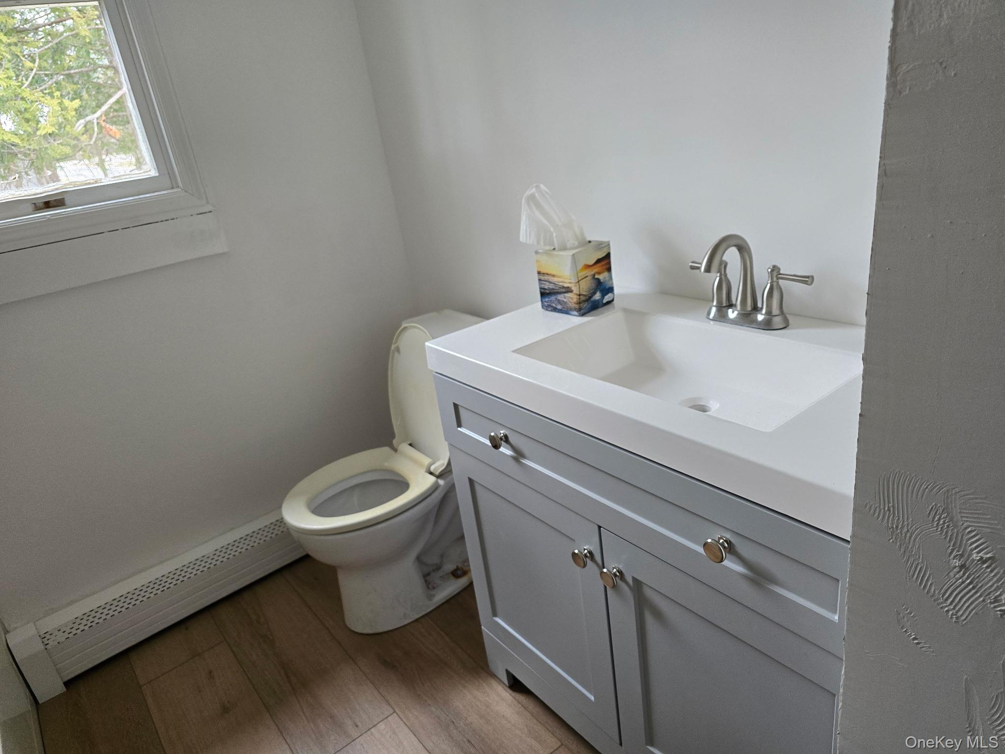 310 A Frowein Road Center Moriches, NY 11934 - Photo 5 of 5 a bathroom with a toilet sink vanity and window
