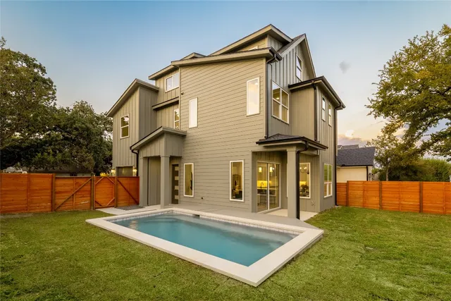 a view of a house with pool and a yard