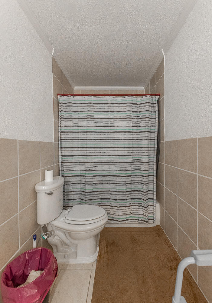 1724 East 2nd Street Lubbock, TX 79403 - Photo 13 of 20 a bathroom with a toilet and a shower