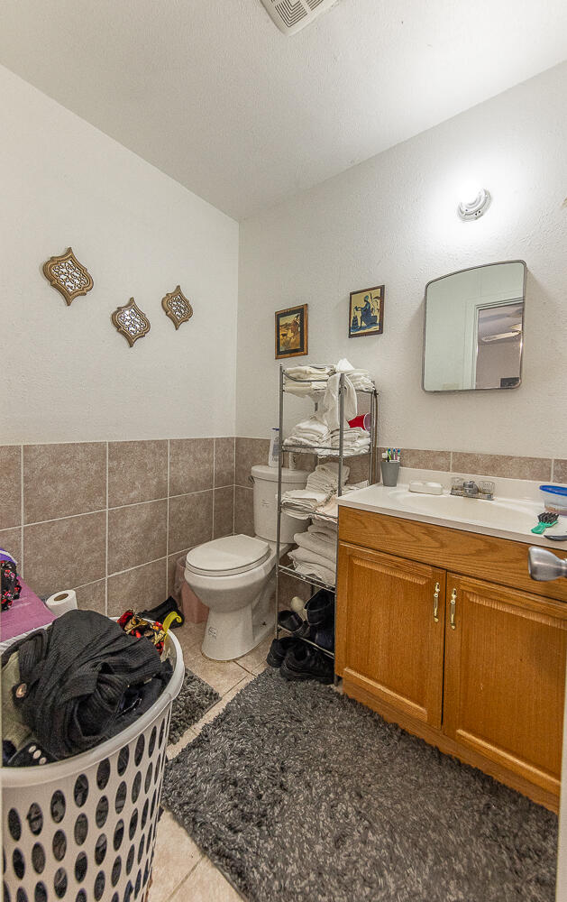 1724 East 2nd Street Lubbock, TX 79403 - Photo 15 of 20 a bathroom with a toilet a sink and mirror