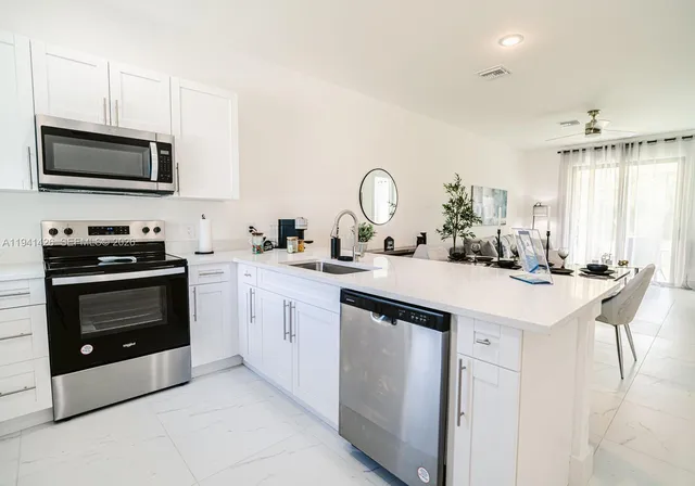 a kitchen with a sink and a stove top oven with wooden floor