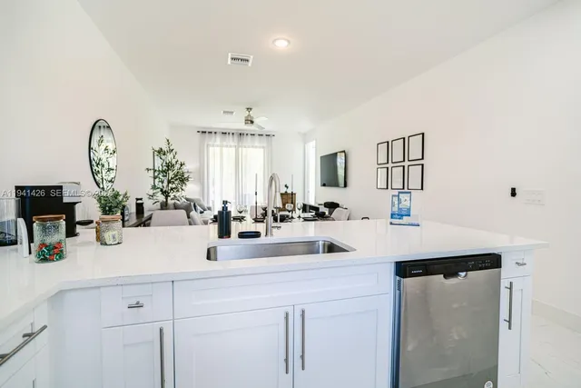 a view of a kitchen counter space a sink and living room view