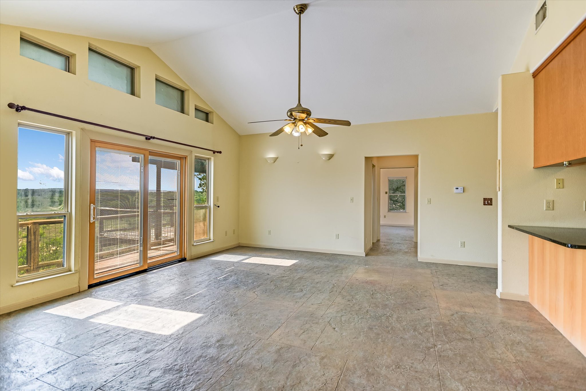 700 Cliffside Road Wimberley, TX 78676 - Photo 2 of 22 Spacious living area featuring a vaulted ceiling and stamped concrete flooring
