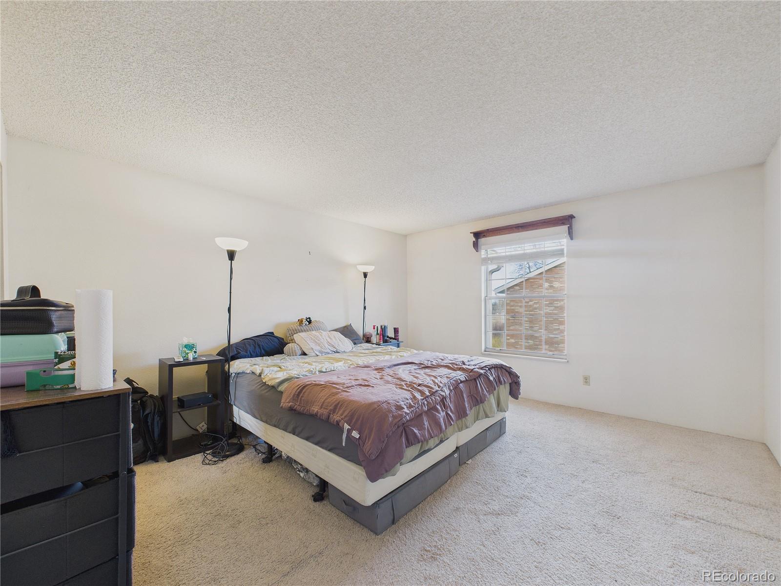 10251 West 44th Avenue, Unit 2203 Wheat Ridge, CO 80033 - Photo 15 of 20 a bed sitting in a bedroom next to a window