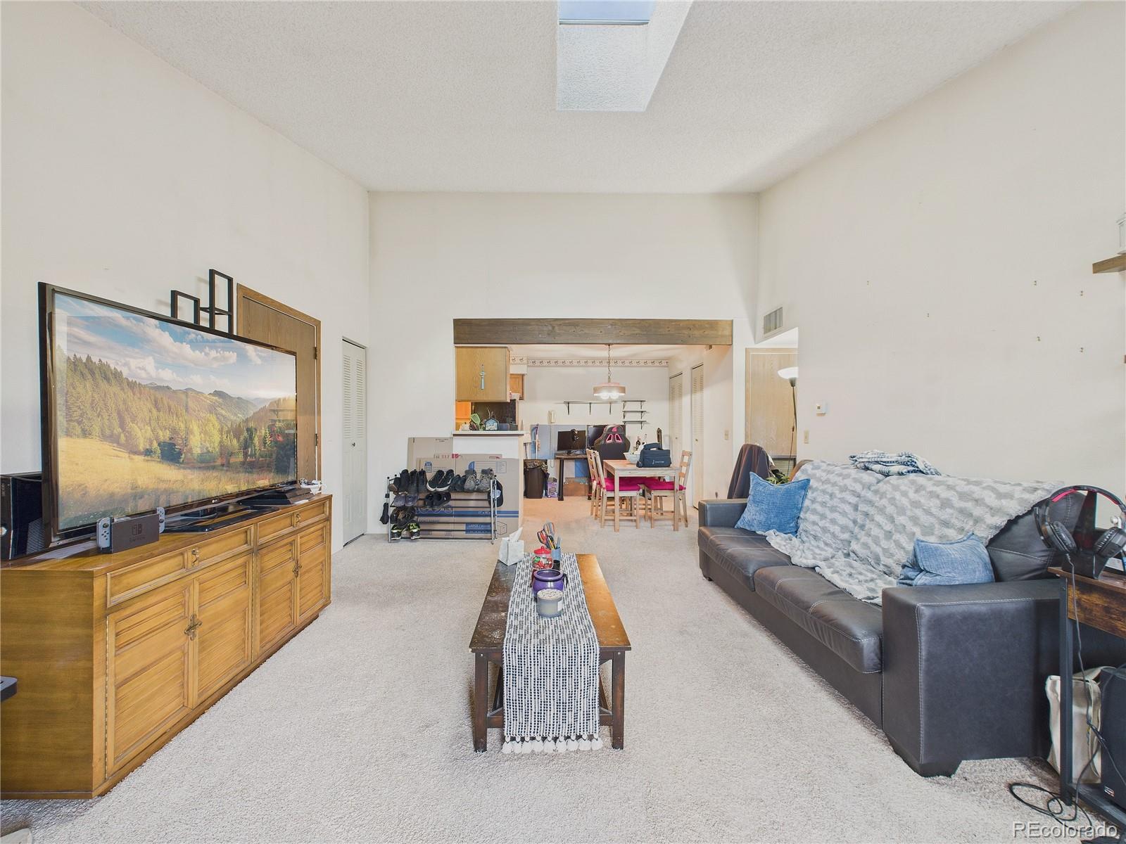 10251 West 44th Avenue, Unit 2203 Wheat Ridge, CO 80033 - Photo 16 of 20 a living room with furniture and a flat screen tv