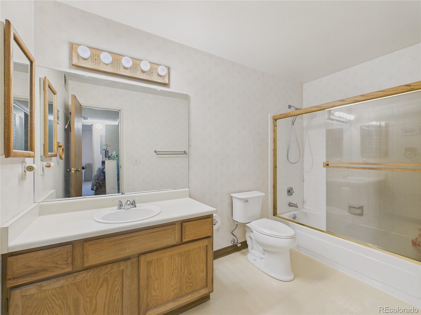 10251 West 44th Avenue, Unit 2203 Wheat Ridge, CO 80033 - Photo 2 of 20 a bathroom with a sink a toilet and shower