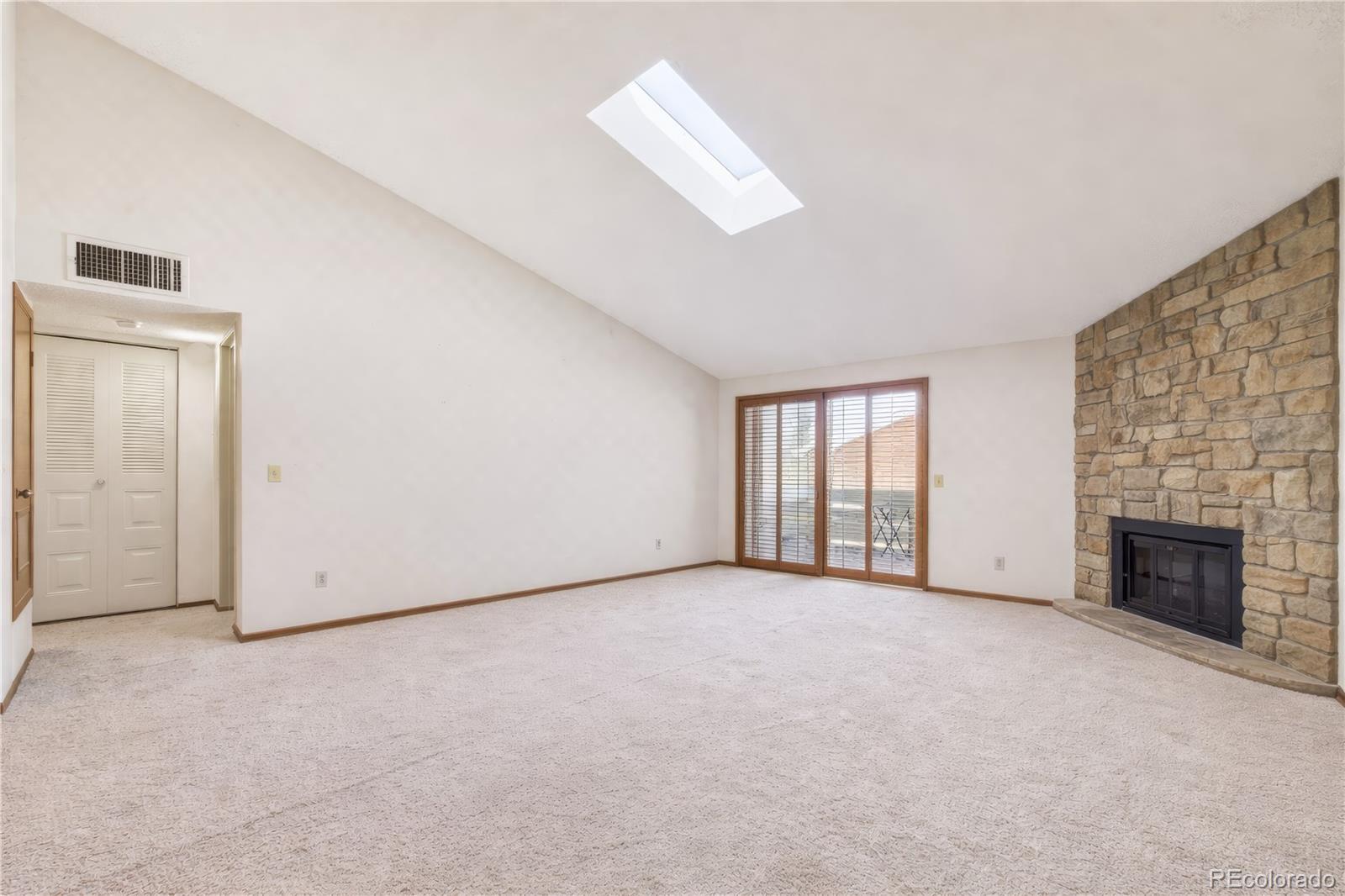 10251 West 44th Avenue, Unit 2203 Wheat Ridge, CO 80033 - Photo 3 of 20 an empty room with windows and fireplace