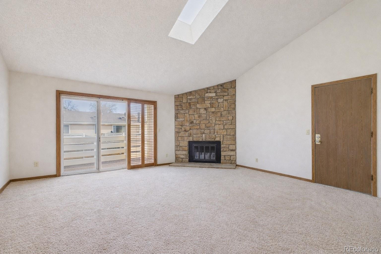 10251 West 44th Avenue, Unit 2203 Wheat Ridge, CO 80033 - Photo 4 of 20 an empty room with furniture and a fireplace