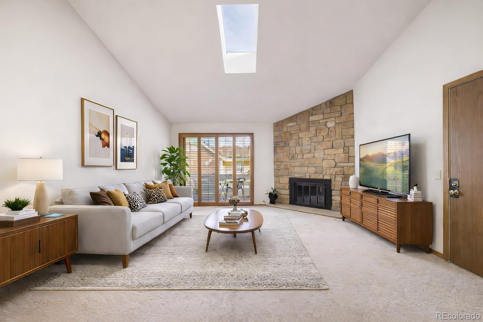 10251 West 44th Avenue, Unit 2203 Wheat Ridge, CO 80033 - Photo 5 of 20 a living room with furniture a fireplace a flat screen tv and a fireplace
