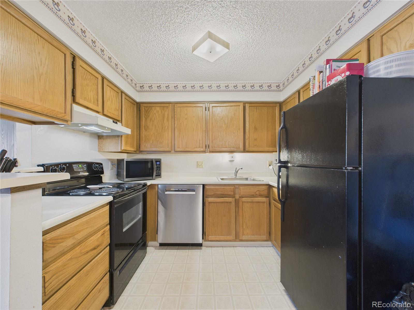 10251 West 44th Avenue, Unit 2203 Wheat Ridge, CO 80033 - Photo 6 of 20 a kitchen with a refrigerator sink and stove