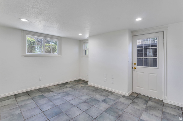 226 North 300 West Provo, UT 84601 - Photo 10 of 14 Room featuring square tile flooring, white walls, recessed lighting, and a white paneled door with glass inserts