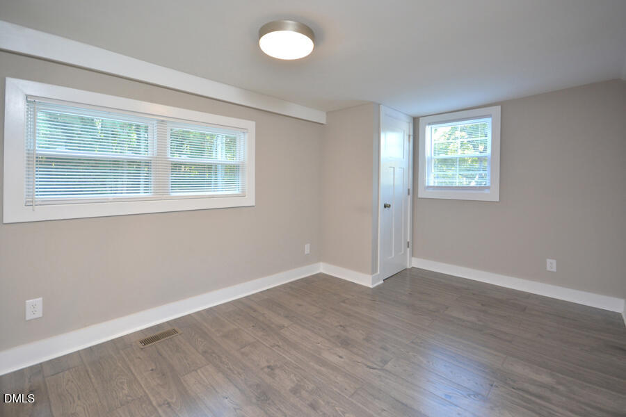 721 Peyton Avenue Durham, NC 27703 - Photo 20 of 25 an empty room with wooden floor and windows