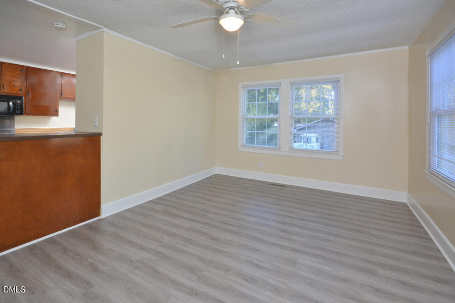 721 Peyton Avenue Durham, NC 27703 - Photo 6 of 25 a view of an empty room with a window and wooden floor