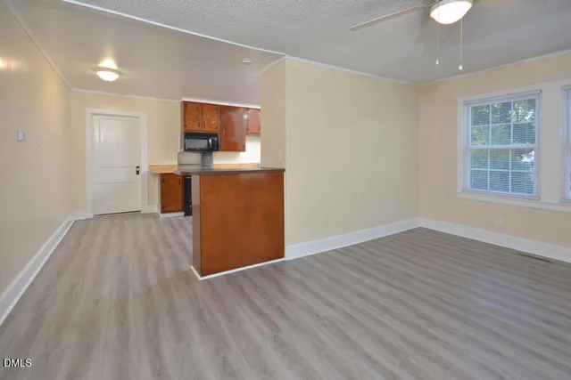 a view of a room with wooden floor and a window