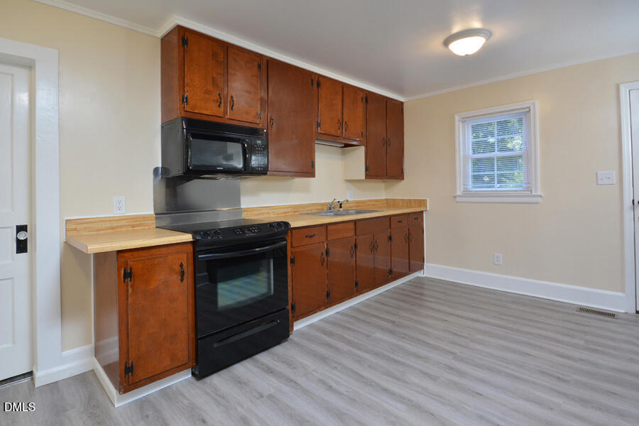 721 Peyton Avenue Durham, NC 27703 - Photo 9 of 25 a kitchen with stainless steel appliances granite countertop a stove a sink and a microwave