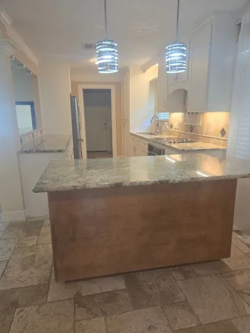 a view of kitchen cabinets and chandelier