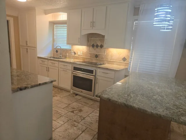a kitchen with kitchen island granite countertop granite top and stainless steel appliances