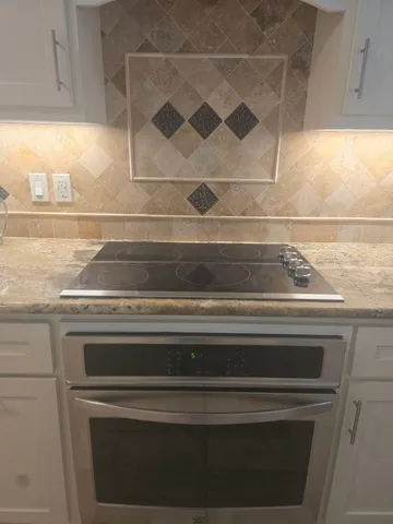 a stove top oven sitting inside of a kitchen