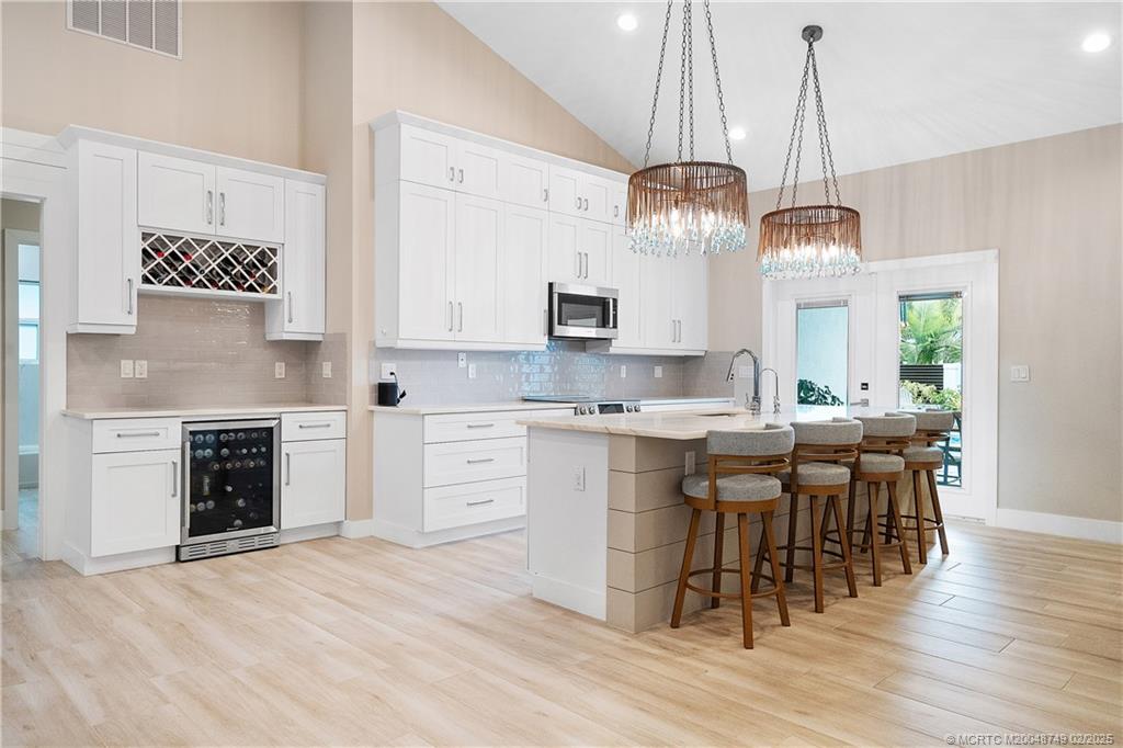 1269 Northwest Fork Road Stuart, FL 34994 - Photo 27 of 92 a view of a kitchen with granite countertop stainless steel appliances stove a sink and dining table with wooden floor