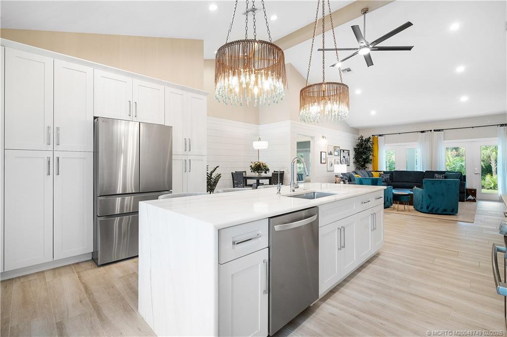 1269 Northwest Fork Road Stuart, FL 34994 - Photo 29 of 92 a kitchen with stainless steel appliances a refrigerator a sink dishwasher a stove and a chandelier