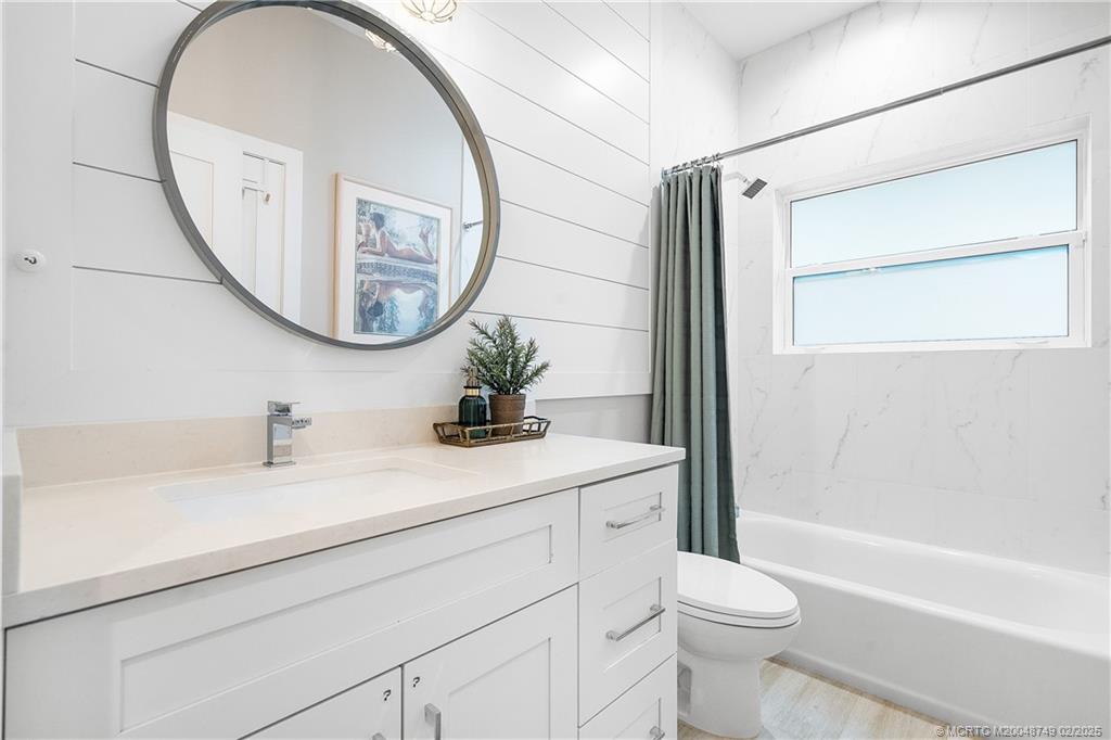 1269 Northwest Fork Road Stuart, FL 34994 - Photo 34 of 92 a bathroom with a sink a toilet and a mirror