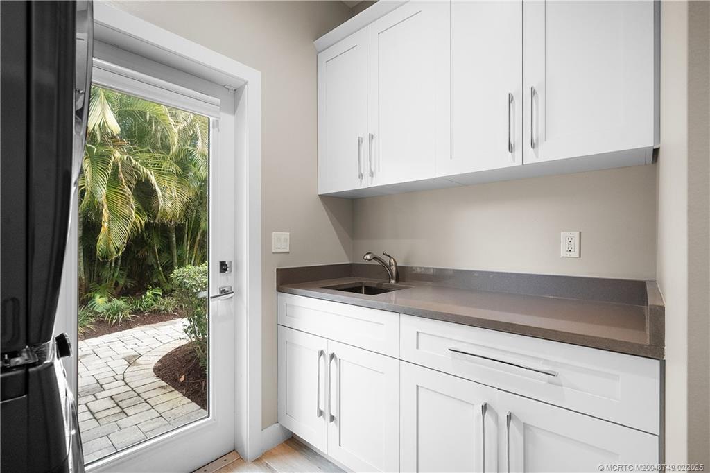 1269 Northwest Fork Road Stuart, FL 34994 - Photo 41 of 92 a kitchen with granite countertop white cabinets and outdoor view