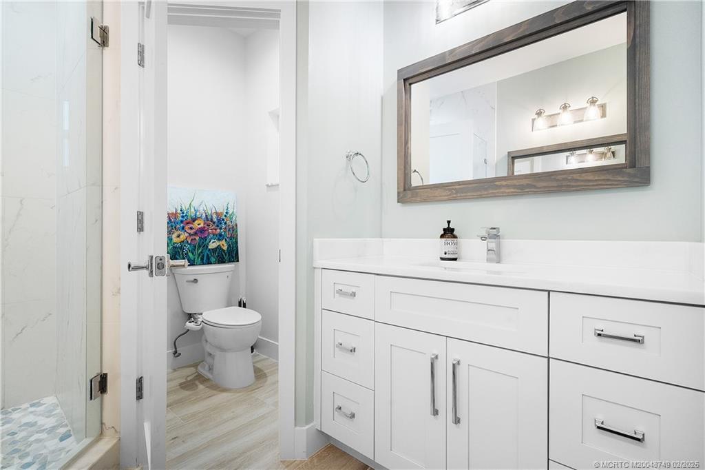 1269 Northwest Fork Road Stuart, FL 34994 - Photo 46 of 92 a bathroom with a toilet a sink and a mirror