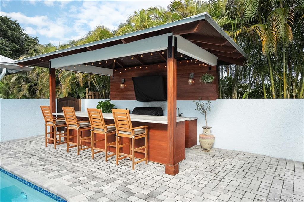 1269 Northwest Fork Road Stuart, FL 34994 - Photo 66 of 92 a view of a patio with table and chairs with wooden floor and fence