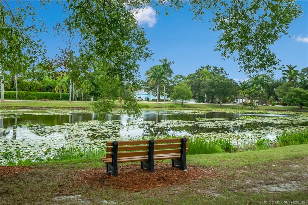 1269 Northwest Fork Road Stuart, FL 34994 - Photo 82 of 92 a view of a bench in the garden near a lake