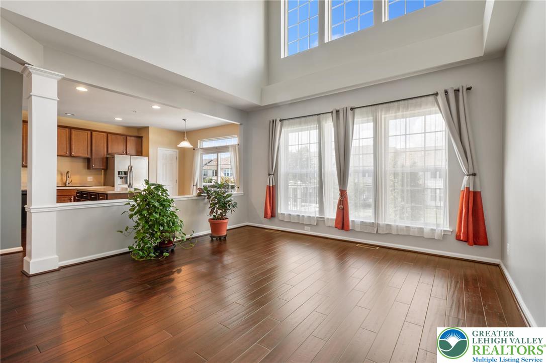 8455 Starling Road Breinigsville, PA 18031 - Photo 2 of 24 Natural light floods this inviting living area, showcasing rich hardwood floors and an open concept layout.