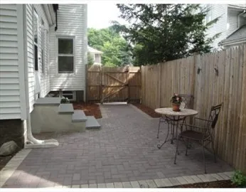 a backyard of a house with table and chairs