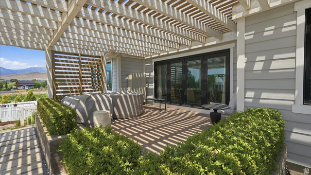2038 East Ranch Road Eagle Mountain, UT 84005 - Photo 52 of 66 Expansive patio featuring a slatted pergola, composite decking, and mature landscaping