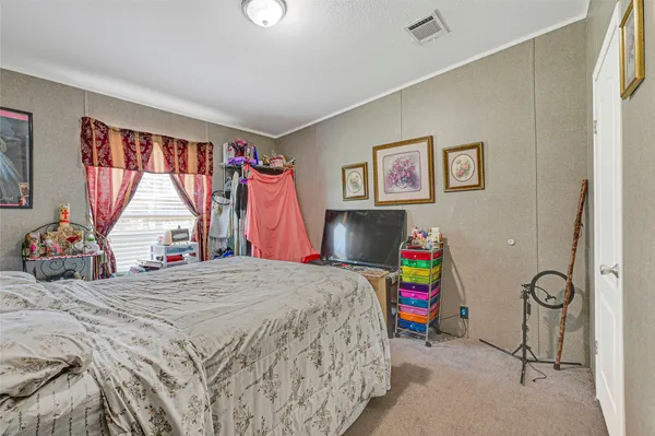 a bedroom with a bed a standing and a large window